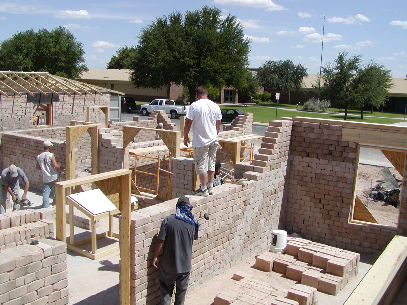 Workers constructing homes with compressed earth blocks